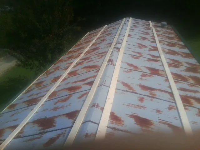 Rusted metal roof panels with new wood purlins before replacement — Storm Damage Roof Repair in Scenery Hill by Roofing Brothers