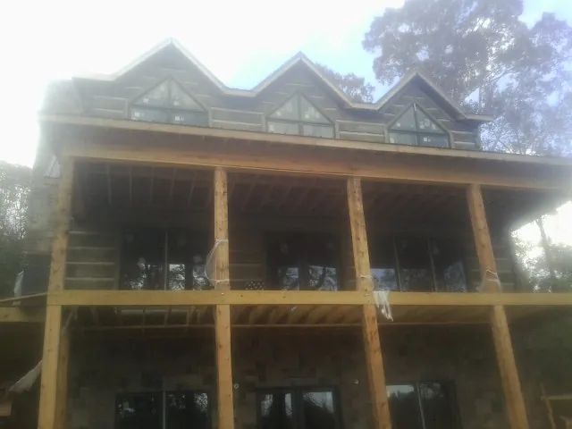 Dormers and porch framing on a large log home under construction — Roof Coating work by our crew in Scenery Hill