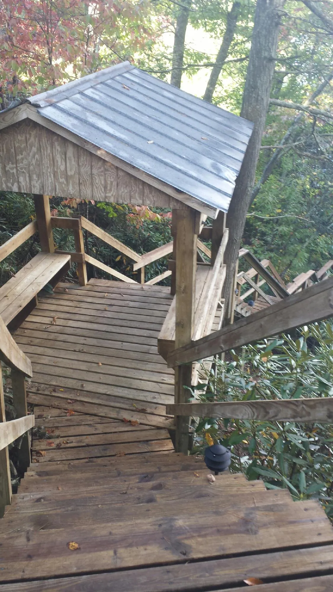 Metal roofed shelter over wooden steps on a wooded walkway — Skylight Repair & Installation work by our crew in Scenery Hill